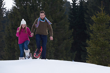 Image showing couple having fun and walking in snow shoes