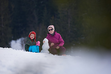 Image showing happy family building snowman