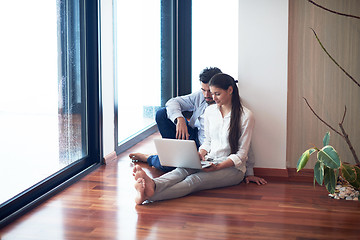 Image showing relaxed young couple working on laptop computer at home