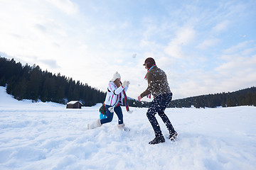 Image showing happy family playing together in snow at winter