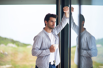 Image showing relaxed young man drink first morning coffee withh rain drops on