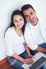 Image showing relaxed young couple working on laptop computer at home