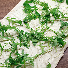 Image showing Making lavash rolls with rucola and cheese