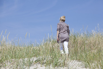 Image showing Vacationer walking through dunes
