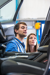 Image showing Sales mechanic showing a woman the interior of a vehicle