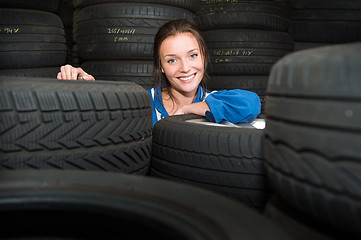 Image showing Portrait of a female mechanic,surrounded by car tyres