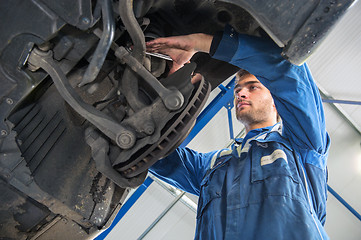 Image showing Mechanic at work on the suspension system of a car