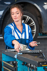 Image showing Mechanic, reaching for tools on a tool trolley in a garage