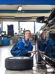 Image showing Female mechanic changing a tyre