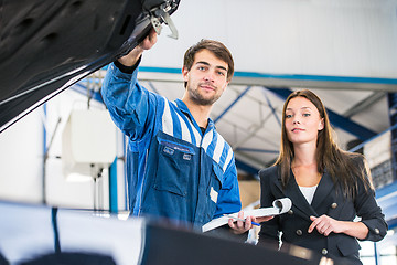 Image showing Mechanic and customer looking under the hood of a car