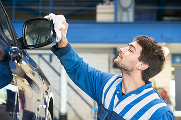 Image showing Mechanic, taking pride in his work, polishing the side mirror ho