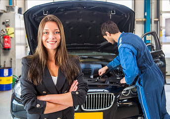 Image showing Happy customer, waiting for a mechanic to fix her car