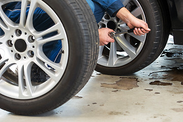 Image showing Mechanic changing tires