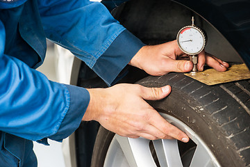 Image showing Measuring tire tread using a gauge 