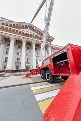 Image showing Builders paint building facade by fire truck