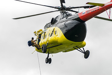 Image showing Rescuer is landed from MI-8 helicopter by rope