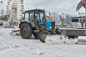 Image showing Tractor with snowplowing equipment cleans street