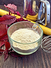 Image showing Flour amaranth in glass cup on board with rolling pin