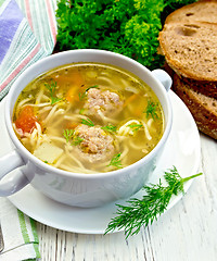 Image showing Soup with meatballs and noodles in bowl on light board