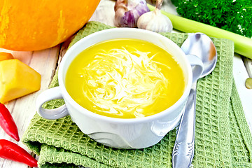 Image showing Soup-puree pumpkin with cream in white bowl on green napkin