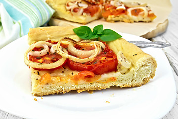 Image showing Pie with onions and tomatoes in white plate on light board