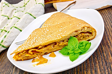 Image showing Pie with cabbage and sesame in plate on board