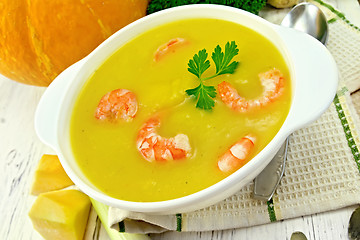 Image showing Soup-puree pumpkin with shrimp in white bowl on board
