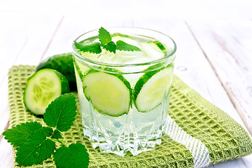 Image showing Lemonade with cucumber and mint in glassful on board