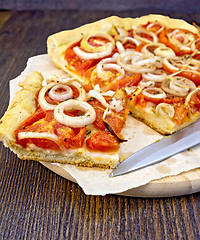 Image showing Pie with onions and tomatoes on parchment and board