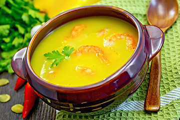 Image showing Soup-puree pumpkin with shrimps in clay bowl on board