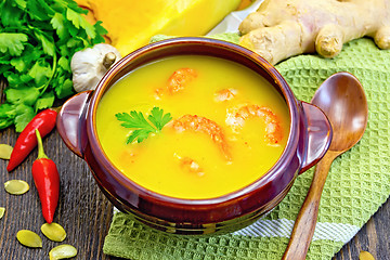 Image showing Soup-puree pumpkin with shrimps in clay bowl on napkin