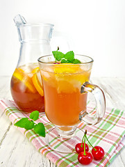 Image showing Lemonade with cherry in wineglass and pitcher on board