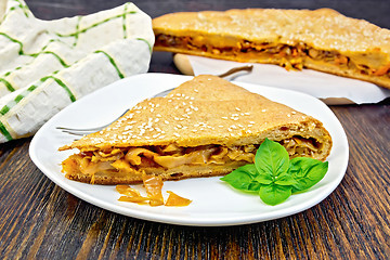 Image showing Pie with cabbage and sesame in plate on board with cloth