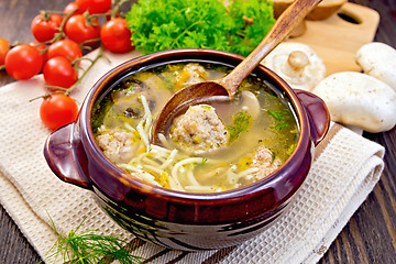 Image showing Soup with meatballs and mushrooms in pottery on board