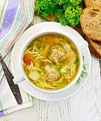 Image showing Soup with meatballs and noodles in bowl on board top