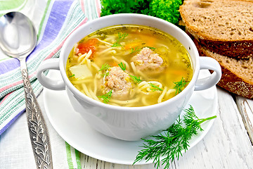 Image showing Soup with meatballs and noodles in bowl on board