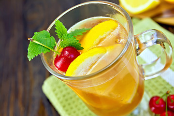 Image showing Lemonade with cherry in wineglass on board