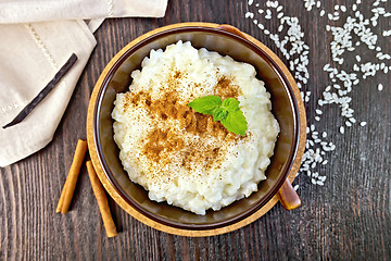 Image showing Rice porridge with cinnamon in bowl on board top