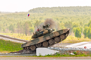 Image showing Tank T-80 overcomes a high concrete obstacle