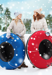 Image showing happy girl friends with snow tubes outdoors