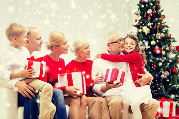 Image showing smiling family with gifts hugging at home