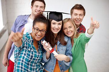 Image showing smiling students with diploma showing thumbs up