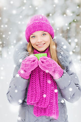 Image showing smiling young woman with cup in winter forest