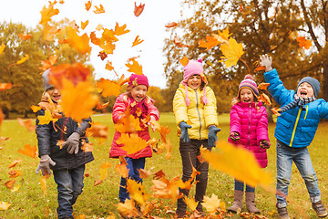 Image showing happy children playing with autumn leaves in park