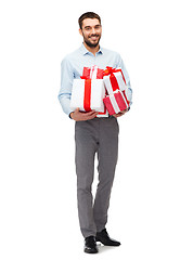 Image showing happy young man holding gift boxes