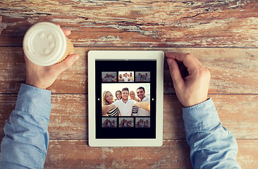 Image showing close up of male hands with photo on tablet pc