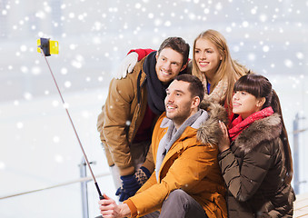 Image showing happy friends with smartphone on skating rink