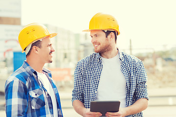 Image showing smiling builders with tablet pc outdoors