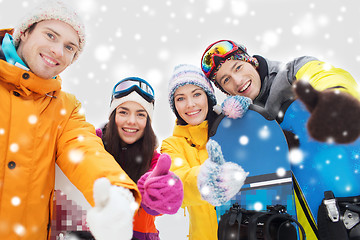 Image showing happy friends with snowboards showing thumbs up