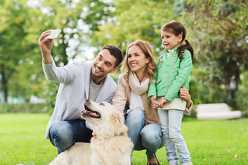 Image showing happy family with dog taking selfie by smartphone